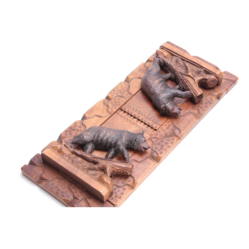 376 - A LATE 19TH CENTURY SWISS BLACK FOREST CARVED ADJUSTABLE BOOKREST with bears to each side on natural... 