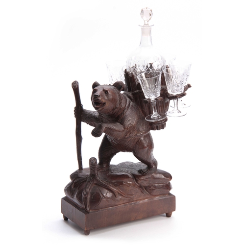 379 - A LATE 19TH CENTURY SWISS CARVED BLACK FOREST BEAR MUSICAL DECANTER SET modelled as a bear carrying ... 