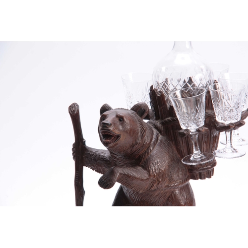 379 - A LATE 19TH CENTURY SWISS CARVED BLACK FOREST BEAR MUSICAL DECANTER SET modelled as a bear carrying ... 