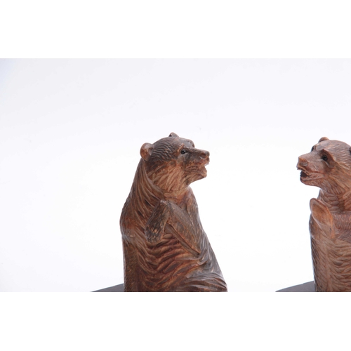 384 - A PAIR OF LATE 19TH CENTURY SWISS CARVED BEAR BOOKENDS depicting two seated bears with glass eyes, m... 