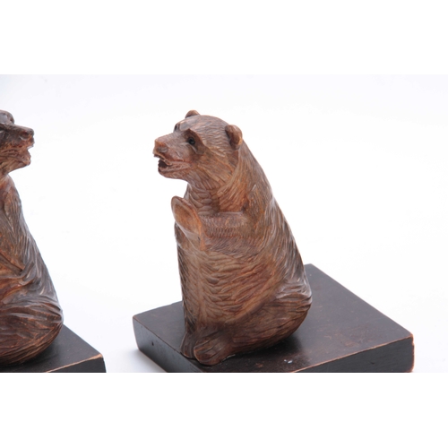 384 - A PAIR OF LATE 19TH CENTURY SWISS CARVED BEAR BOOKENDS depicting two seated bears with glass eyes, m... 