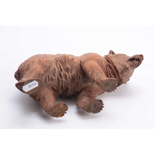 389 - A 19TH CENTURY SWISS BLACK FOREST CARVED BEAR IN THE MANNER OF HUGGLAR with glass eyes 22.5cm wide.