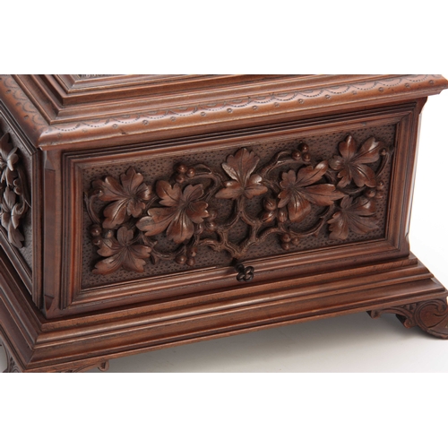 390 - A LATE 19TH CENTURY SWISS WALNUT CIGAR CABINET with carved fruiting leaf work panels to the front an... 