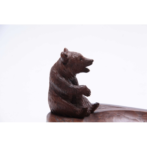 391 - A LATE 19TH CENTURY SWISS BLACK FOREST BEAR DESK TIDY with a seated bear on an oval dished base with... 