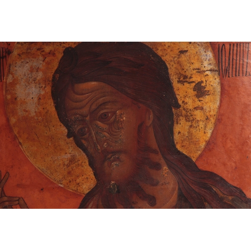 455 - AN EARLY RUSSIAN POLYCHROME PAINTED ICON OF A SAINT on a bowed fruitwood panel 52.5cms high by 41cms... 