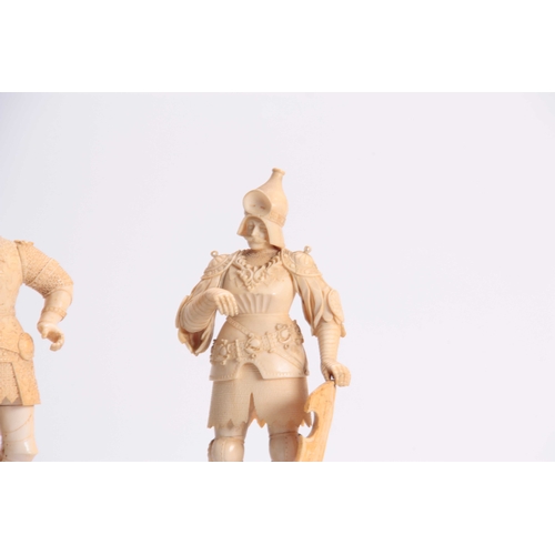 483 - A PAIR OF 19th CENTURY CARVED IVORY FIGURES modelled as knights in armour standing on turned ebonize... 