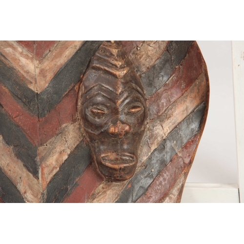 486 - AN AFRICAN PAINTED WOODEN TRIBAL CEREMONIAL SHIELD with four carved heads 76cm high