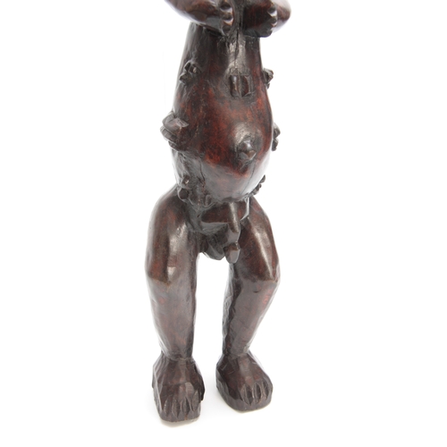 490 - A LATE 19th/EARLY 20th CENTURY CARVED AFRICAN TRIBAL FIGURE modelled as a standing naked man 70cm hi... 