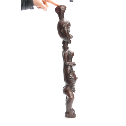 490 - A LATE 19th/EARLY 20th CENTURY CARVED AFRICAN TRIBAL FIGURE modelled as a standing naked man 70cm hi... 