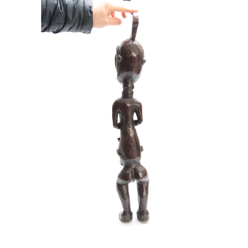 490 - A LATE 19th/EARLY 20th CENTURY CARVED AFRICAN TRIBAL FIGURE modelled as a standing naked man 70cm hi... 