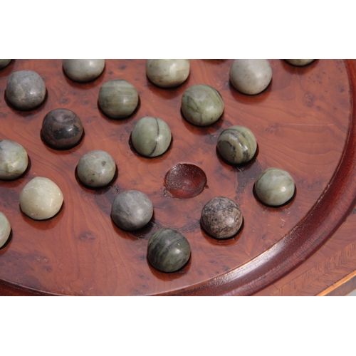 531 - A 19TH CENTURY HERRING-BANDED YEW-WOOD SOLITAIRE BOARD with green marbles; standing on small brass f... 