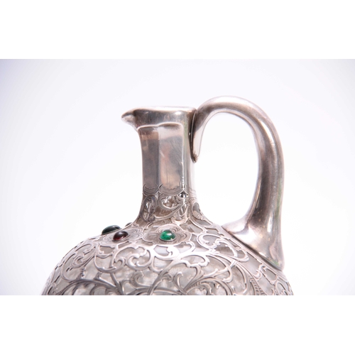 567 - A 19TH CENTURY JEWELLED AND BRIGHT CUT SILVER FILIGREE OVERLAID GLASS CLARET JUG of flattened ovoid ... 