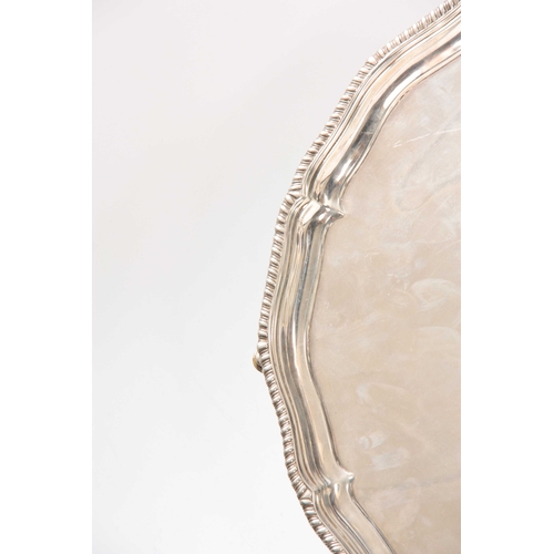 573 - A LARGE LATE 19th CENTURY SILVER SALVER with pie crust edge supported on four cabriolet feet 45cm di... 