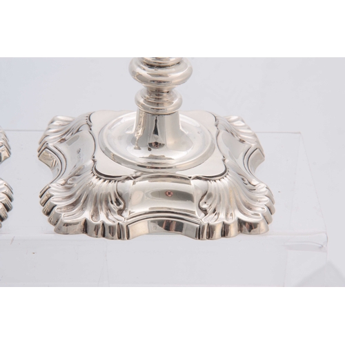 589 - A PAIR OF 20TH CENTURY GEORGE II STYLE ROCOCO SILVER CANDLESTICKS with shell corners and ringed stem... 