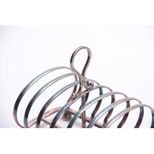 601 - A VICTORIAN SILVER TOAST RACK of six divisional hooped form with raised ring handle and facetted fee... 