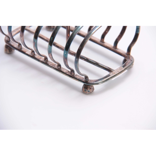 601 - A VICTORIAN SILVER TOAST RACK of six divisional hooped form with raised ring handle and facetted fee... 