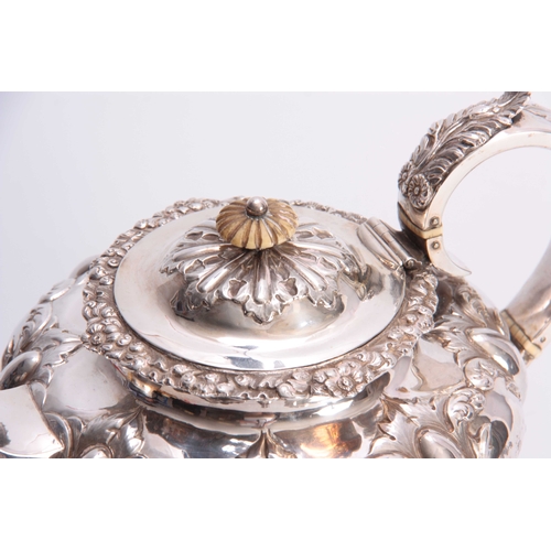 603 - A VICTORIAN SILVER TEAPOT OF LARGE SIZE of circular footed form with hinged lid and leaf capped hand... 