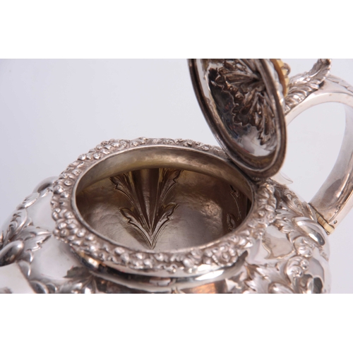 603 - A VICTORIAN SILVER TEAPOT OF LARGE SIZE of circular footed form with hinged lid and leaf capped hand... 