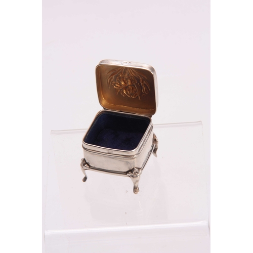 607 - AN ART NOUVEAU SILVER EMBOSSED LIDDED BOX having a stylish lily design to the hinged lid supported o... 