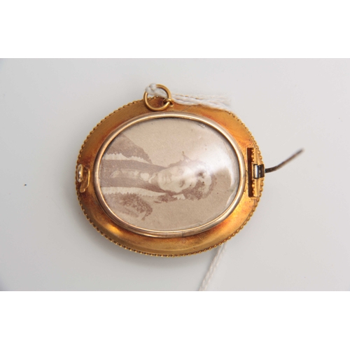 668 - A LATE VICTORIAN 15CT YELLOW GOLD OVAL MOURNING BROOCH with scrolled hair spray centre enclosed by a... 