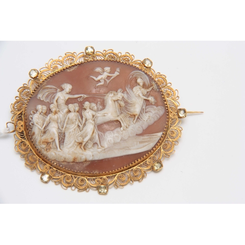 733 - A LARGE CAMEO BROOCH depicting a horse-drawn chariot and figure panel within a fine scrolled filigre... 