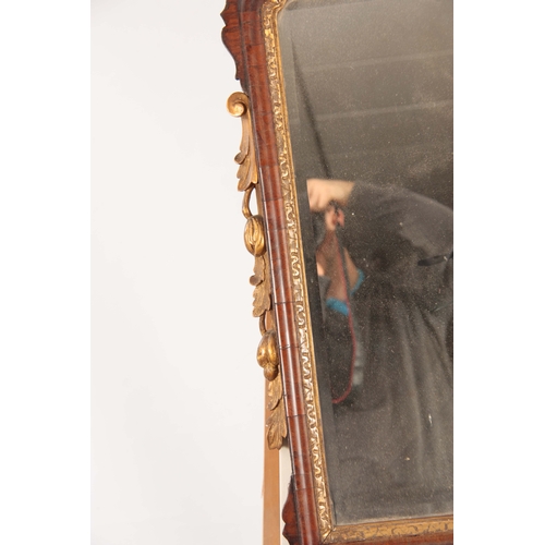 1032 - A GEORGE II WALNUT HANGING MIRROR with shaped fret cut surround having gilt carved crest and leaf wo... 