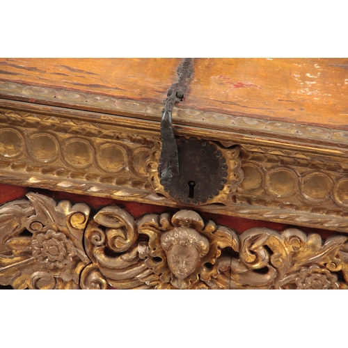 1041 - AN 18TH CENTURY ITALIAN CARVED GILTWOOD COFFER with baroque style carved front, above an iron strapp... 