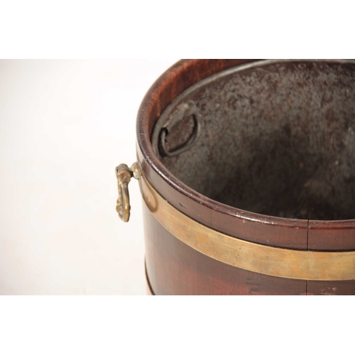 1050 - A GEORGE III MAHOGANY CIRCULAR BRASS BOUND PEAT BUCKET with ringed brass hoops and side carrying han... 