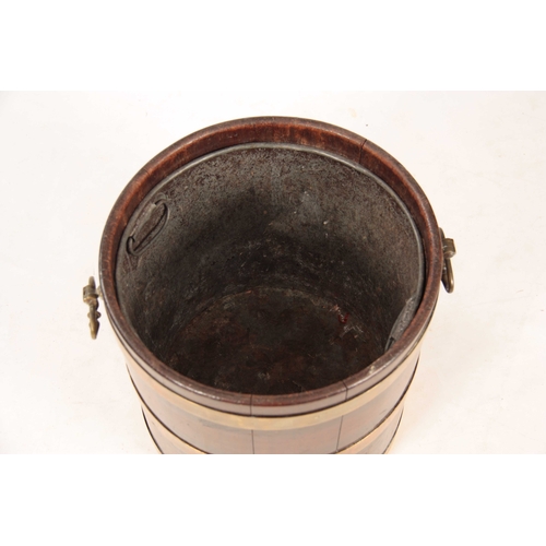 1050 - A GEORGE III MAHOGANY CIRCULAR BRASS BOUND PEAT BUCKET with ringed brass hoops and side carrying han... 