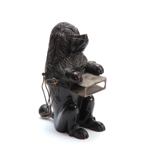 925 - A 19TH CENTURY CARVED EBONISED SMOKERS COMPENDIUM formed as a dog with pipe holders to the sides and... 