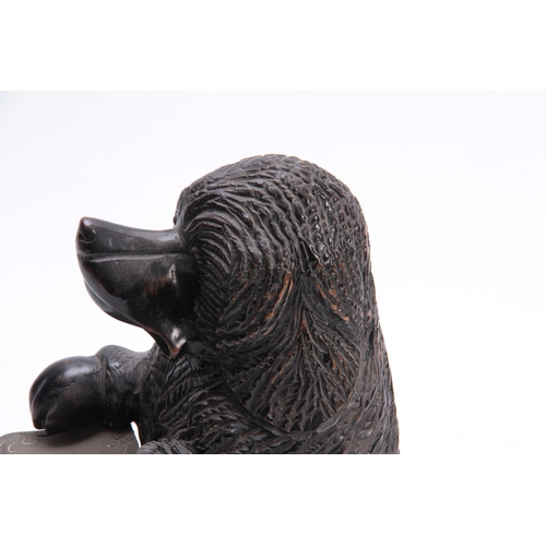 925 - A 19TH CENTURY CARVED EBONISED SMOKERS COMPENDIUM formed as a dog with pipe holders to the sides and... 