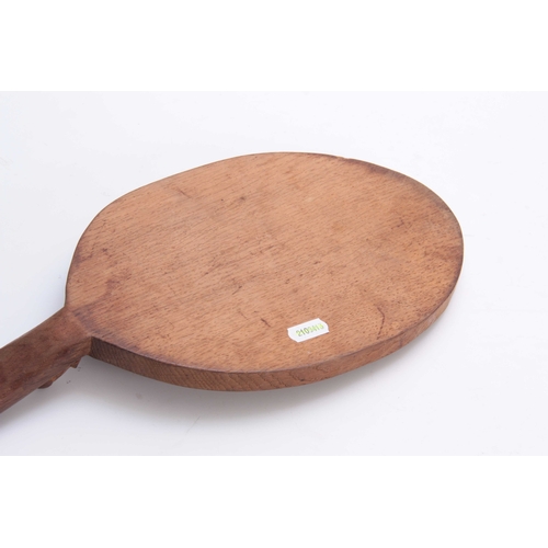 933 - A ROBERT MOUSEMAN THOMPSON OAK CHEESEBOARD of oval form with curved handle carved with a mouse trade... 