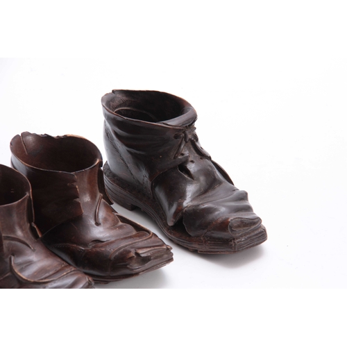 939 - A PAIR AND SINGLE LATE 19TH CENTURY SWISS CARVED BOOTS the pair 15cm wide the single 16cm wide (3).