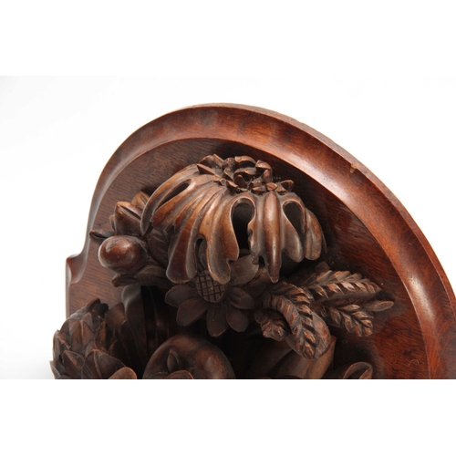 941 - A LATE 19th CENTURY WALNUT AND OAK CARVED BRACKET having a floral spray and fruit 30cm high