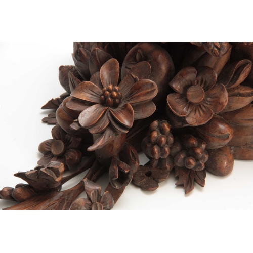 941 - A LATE 19th CENTURY WALNUT AND OAK CARVED BRACKET having a floral spray and fruit 30cm high