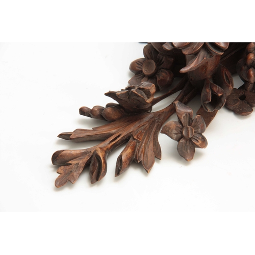 941 - A LATE 19th CENTURY WALNUT AND OAK CARVED BRACKET having a floral spray and fruit 30cm high