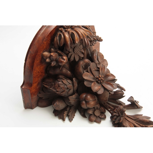 941 - A LATE 19th CENTURY WALNUT AND OAK CARVED BRACKET having a floral spray and fruit 30cm high