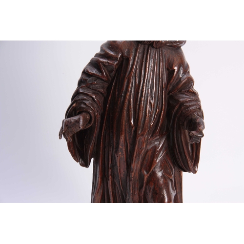 947 - A 17TH CENTURY CARVED LIMEWOOD FIGURE OF A SAINT finely carved with a good patination 48cm high.