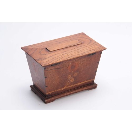 953 - AN ARTS AND CRAFT INLAID OAK TEA CADDY of tapered form with moulded hinged top above a floral inlaid... 