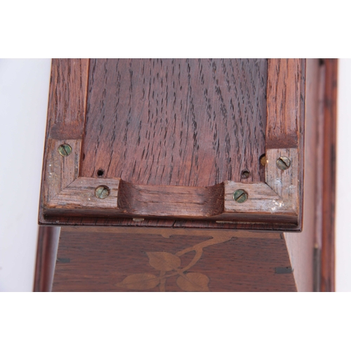 953 - AN ARTS AND CRAFT INLAID OAK TEA CADDY of tapered form with moulded hinged top above a floral inlaid... 