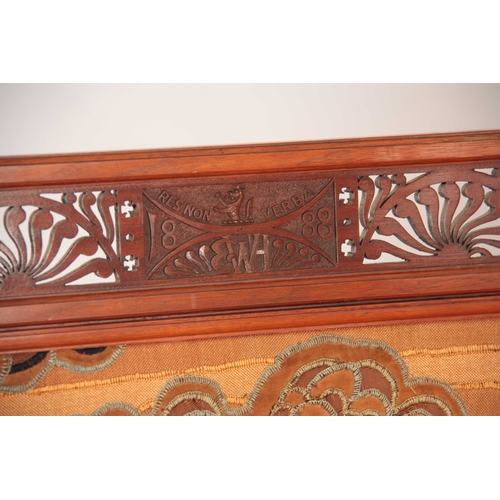 967 - AN ARTS AND CRAFTS WALNUT EMBROIDERED SCREEN having pierced stylised fret work top, with initials EW... 