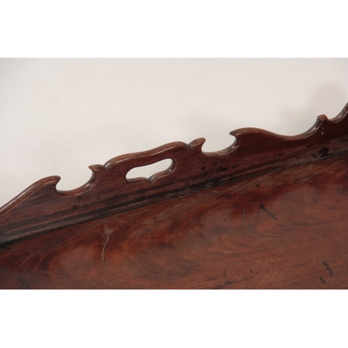 974 - A GEORGE III FIGURED MAHOGANY RECTANGULAR TRAY with shaped gallery and cutout side handles 58cm wide... 