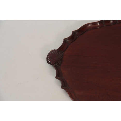 975 - A 19TH CENTURY MAHOGANY OVAL SHAPED MAHOGANY TRAY with a pie crust edge, having carved shell handles... 