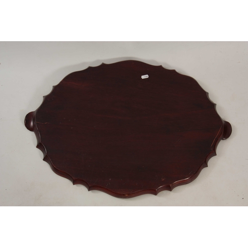 975 - A 19TH CENTURY MAHOGANY OVAL SHAPED MAHOGANY TRAY with a pie crust edge, having carved shell handles... 