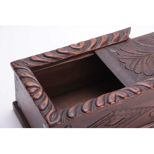 979 - A LATE 17TH CENTURY CARVED OAK CANDLE BOX with sliding top having a gadrooned edge and flower carved... 