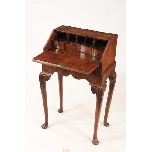 982 - A GEORGE I STYLE WALNUT BUREAU ON STAND with angled fall revelling an interior of pigeon holes and s... 