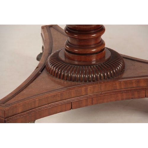 987 - A REGENCY PLUM PUDDING MAHOGANY CENTRE TABLE with wide cross-banded tilt top; standing on a ring tur... 