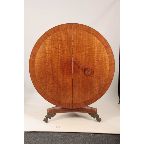 987 - A REGENCY PLUM PUDDING MAHOGANY CENTRE TABLE with wide cross-banded tilt top; standing on a ring tur... 