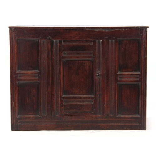 993 - A 17TH CENTURY OAK WELSH HANGING FOOD CUPBOARD constructed of joined panels with central hinged door... 