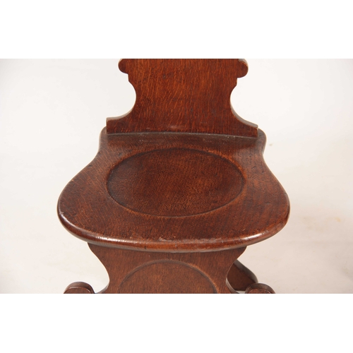 994 - A PAIR OF GEORGE II OAK HALL CHAIRS the slightly bowed shaped solid backs on dished rounded seats an... 